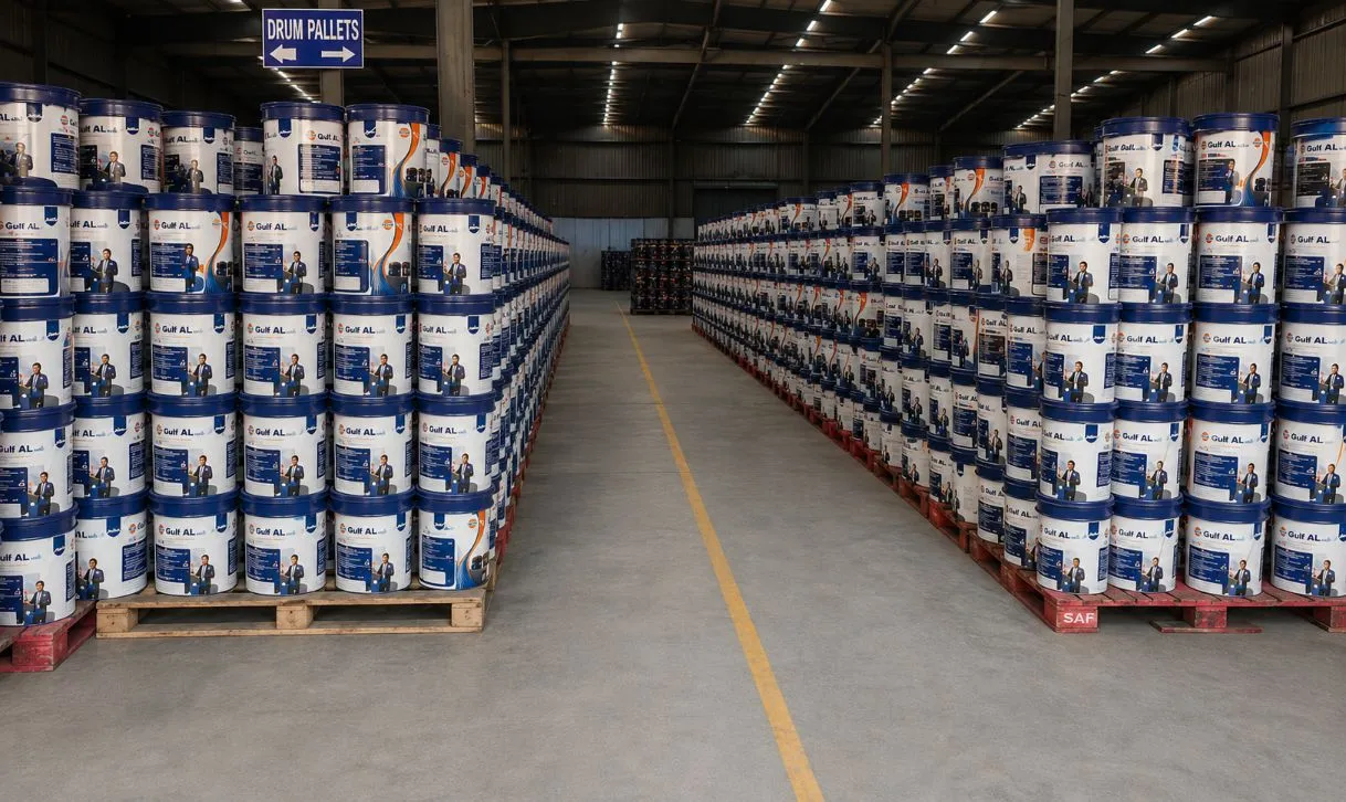 Aisle of lubricant buckets on pallets under a drum pallets sign